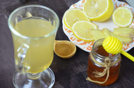 Hot drink with honey, lemon and ginger for cough remedy on wooden tableの写真素材