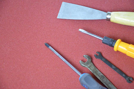 Top view of Working tools,wrench,socket wrench,hammer,screwdriver,plier,electric drill,tape measure,machinist square on wooden board. flat lay design.の写真素材