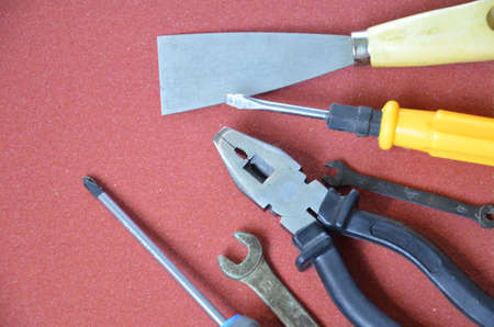 Top view of Working tools,wrench,socket wrench,hammer,screwdriver,plier,electric drill,tape measure,machinist square on wooden board. flat lay design.の写真素材