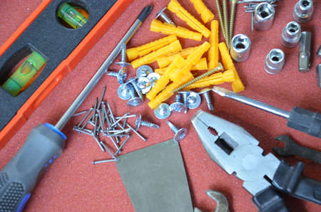Top view of Working tools,wrench,socket wrench,hammer,screwdriver,plier,electric drill,tape measure,machinist square on wooden board. flat lay design.の写真素材