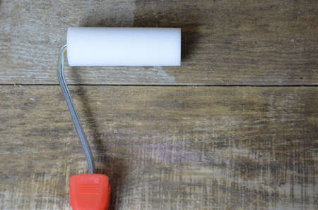 White paint, paint brush, roller for paint, repair concept. for painted surface with a waterproof paint by cushion and brushの写真素材