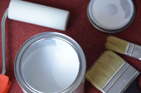 White paint, paint brush, roller for paint, repair concept. for painted surface with a waterproof paint by cushion and brushの写真素材