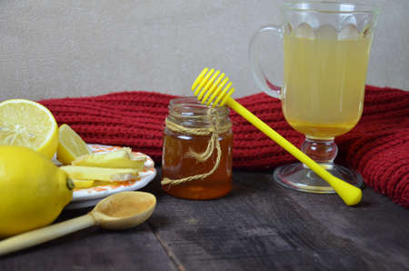 A glass cup of green natural tea with ginger, lemon, mint and honey on wooden rustic background. Healthy drink. alternative medicine improving immunityの写真素材