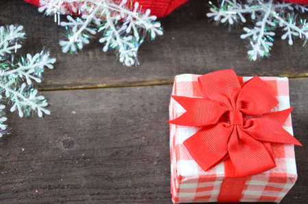 Romantic gift with candles on wooden background. Love concept. gift wrapped with a red bow, candles in the shape of a heart, on a background of scabby clothes, scarf, rope, snowflakes. St. Valentine's Dayの写真素材
