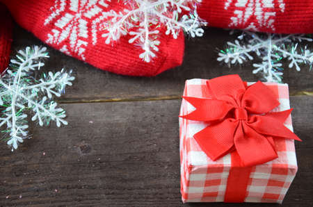 Romantic gift with candles on wooden background. Love concept. gift wrapped with a red bow, candles in the shape of a heart, on a background of scabby clothes, scarf, rope, snowflakes. St. Valentine's Dayの写真素材