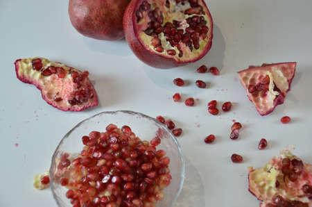 Bowl of fresh red pomegranate seeds on white backgroundの写真素材