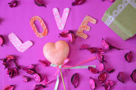 heart on a crimson background with rose petals. concept of love. roses hearts and copy space. valentine day conceptの写真素材