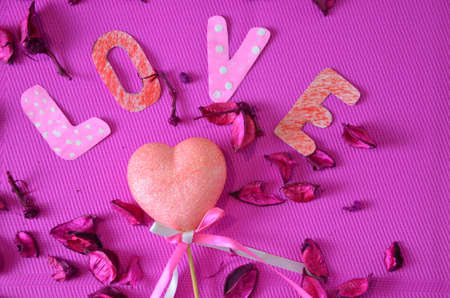 heart on a crimson background with rose petals. concept of love. roses hearts and copy space. valentine day conceptの写真素材