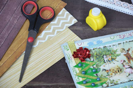 Top view of table with elements for scrapbooking, tools for decoration and handmade albums and cards. Craft materials. hobby. gift for christmas, new yearの写真素材