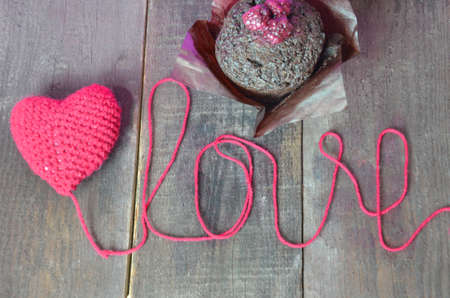 Close up red hand-made knitting crochet heart on wooden background . Love and care concepts. Valentine's day.の写真素材