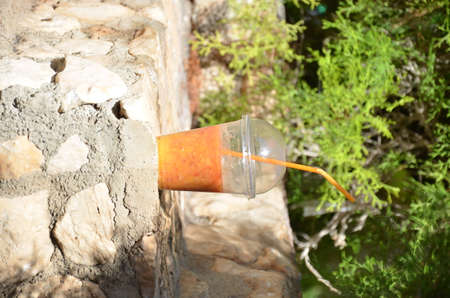 Orange smoothies, juice, cocktail of fresh fruit carrots orange on a background of stones in the city. concept travel vacation, diet, healthの写真素材