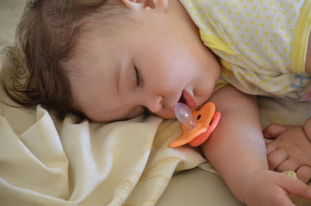 Cute newborn baby sleeps, open mouth, nipple fell outの写真素材