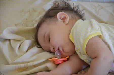 Cute newborn baby sleeps, open mouth, nipple fell outの写真素材