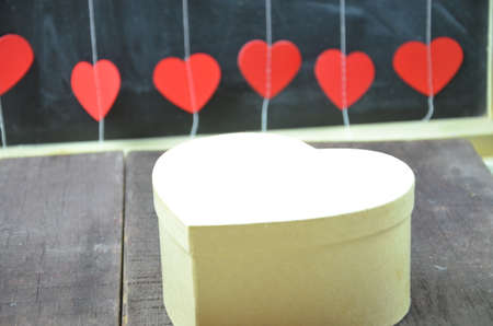 gift box with a red heart background on old wooden table. Valentine day.の写真素材