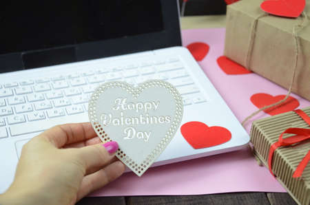 The concept - shop online. White laptop computer with red gift box and a small red heart on the table. top view. Copy space. Closeupの写真素材