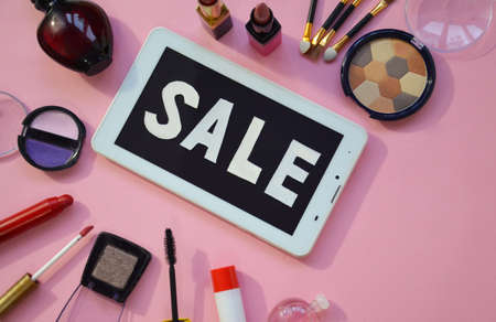 makeup cosmetics and brushes with tablet computer on wooden tableの写真素材