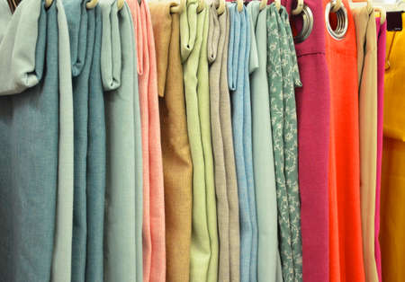 Colorful curtain samples hanging from hangers on a rail in a display in a retail storeの写真素材