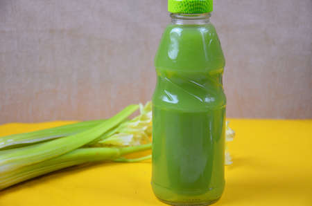 Healthy detox juice in glass bottles on soft orange yellow background. Colorful bottles. Healthy organic drink. Different tastesの写真素材