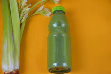 Healthy detox juice in glass bottles on soft orange yellow background. Colorful bottles. Healthy organic drink. Different tastesの写真素材