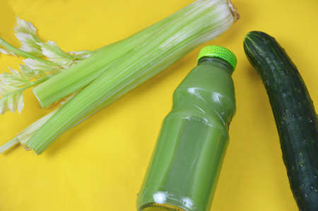 Fresh Green Juice with cucumber, celery on yellow backgroundの写真素材