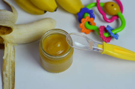 Baby food, banana mashed puree and bananas on a white backgroundの写真素材