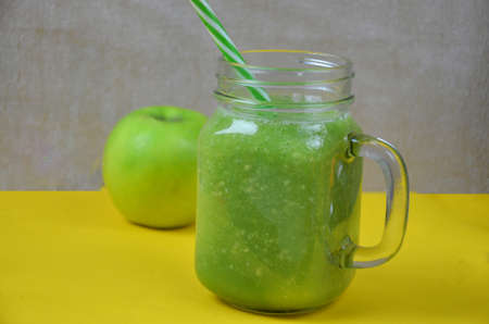 Detox green smoothie juice with celery, cucumber, dill and apple on a yellow background. Healthy food.の写真素材