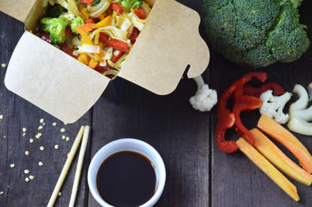 Chinese food, Noodles with vegetables in take-out box on wooden tableの写真素材