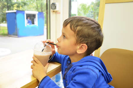 Little boy drinking milkshake through a strawの写真素材