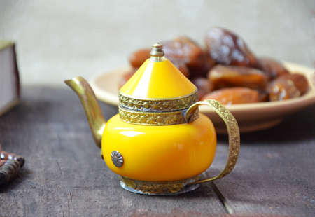 tea ceremony on the river bank. process of brewing tea in nature using a glass teapot. shepherd with cups, a teapot and tea tongs from the front view in perspective close with the river at sunsetの写真素材