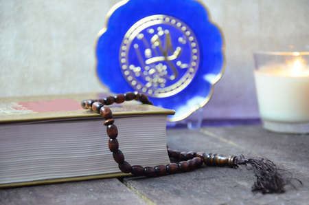 Table top view aerial image of decoration Ramadan Kareem holiday background.Flat lay date with brown rosary candle lighting.Holy book of Koran on modern rustic white cloth at office desk and space.の写真素材