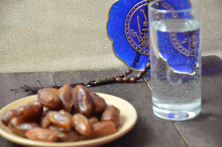 A glass of drinking water and date fruits - a food that is consumed before breaking fast during holy month of Ramadan.の写真素材