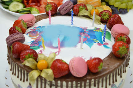 Hand cut the birthday cake with knifeBirthday cake with the inscription. A table full of sweets and snacksの写真素材