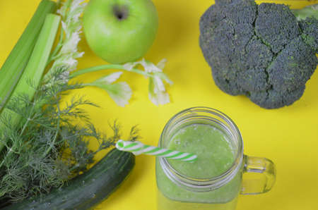 Detox healthy green smoothie in mason jar with ingredients: spinach, celery, cucumber, lettuce, ginger, fennel, lime and broccoli on a tray on white wooden background. Clean eating concept. Top view.の写真素材