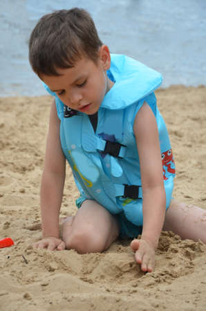 Cute baby boy playing with beach toysの写真素材