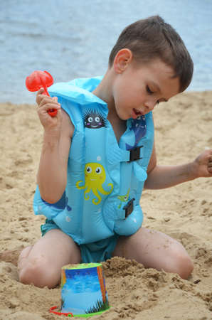Cute baby boy playing with beach toysの写真素材