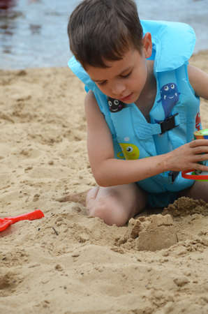 Cute baby boy playing with beach toysの写真素材