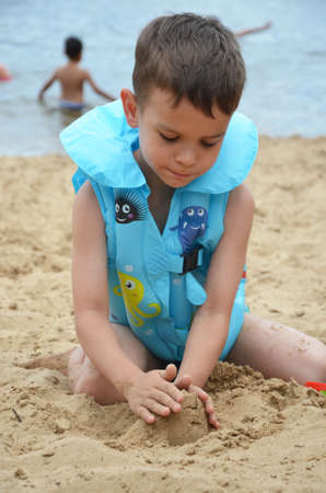 Cute baby boy playing with beach toysの写真素材