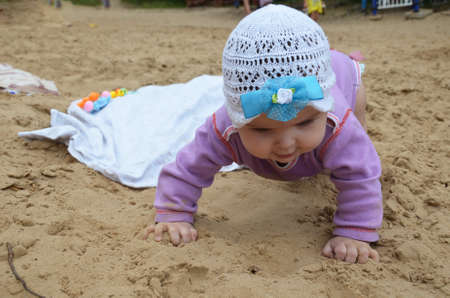 Small girl sitting on sand at beachの写真素材