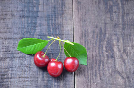 Fresh cherries in basket on wooden tableの写真素材