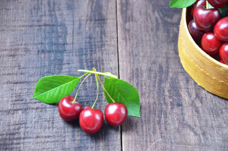 Fresh cherries in basket on wooden tableの写真素材