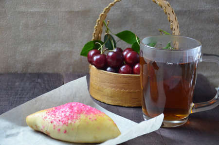 Cherry homemade russian pies on wooden background. with cherry in the basketの写真素材