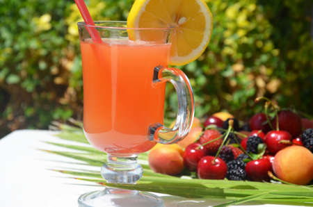 extremely close up glass of tasty tropical alcohol cocktail with berries or lemonade with beautiful...