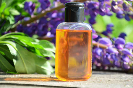 brown jar with oil. organic cosmetic with purple flowers and oil on foliage background. spa concept, perfumeryの写真素材
