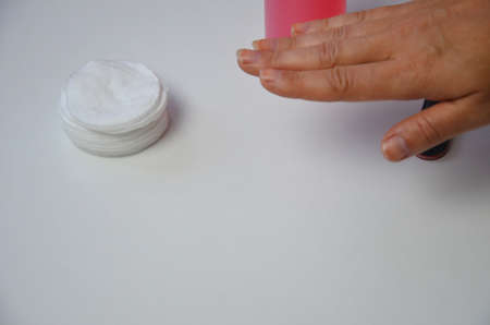 The girl does manicure nails nail file undermining with pink nail polish. Close-up of a hand nearの写真素材