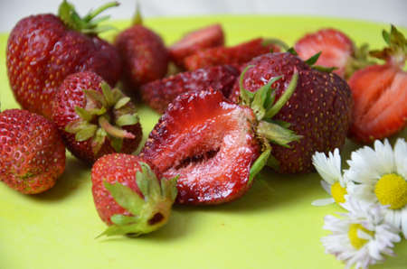 strawberry slice red background. on a green board with flowers. close-up top viewの写真素材