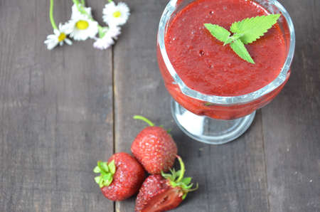 Jars of strawberry jam or jelly with berries and spoon on brown woodwn background close up top view, copy spaceの写真素材