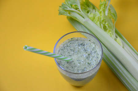 Vegetable smoothie made of celery leaf and broccoli, healthy life style food on yellow background, copy spaceの写真素材