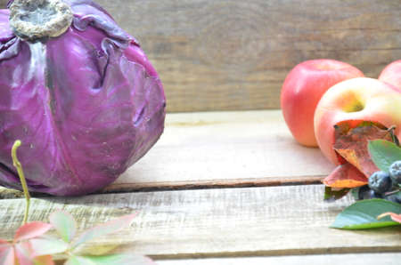 fresh purple red cabbage on cutting board on wood table with copy space. Homemade food concept. Autumn harvest. Background of fruit apples and grapes.の写真素材