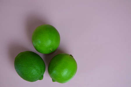 lime juice with lime leaves on pink table. Detox diet. top view. copy space. three limesの写真素材