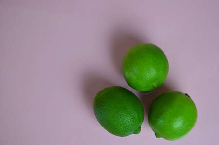 lime juice with lime leaves on pink table. Detox diet. top view. copy space. three limesの写真素材
